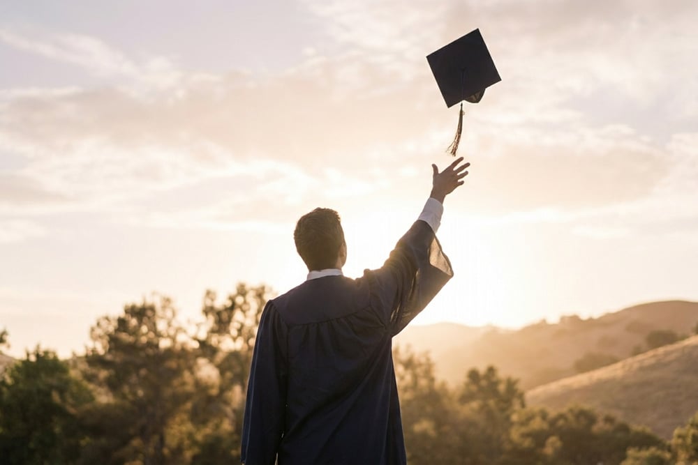 A graduation cap and rolled diploma